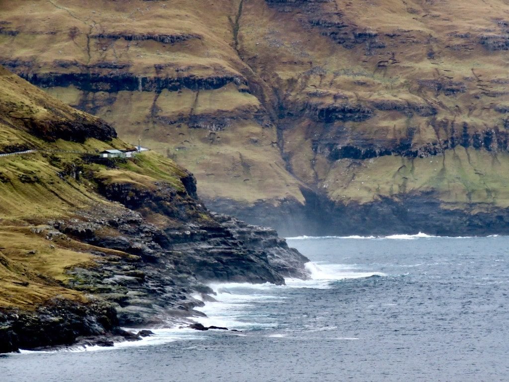 The faroe islands are surrounded by breathtaking cliffs